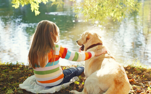 Bambina e cane davanti al lago