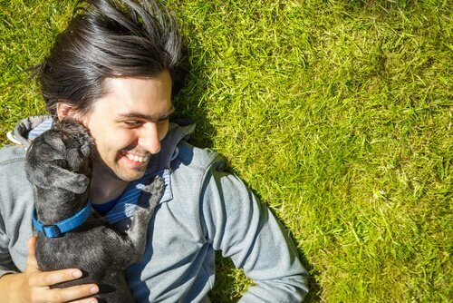 padrone sdraiato sull'erba con cucciolo