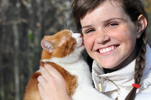 gatto lecca la guancia di una ragazza