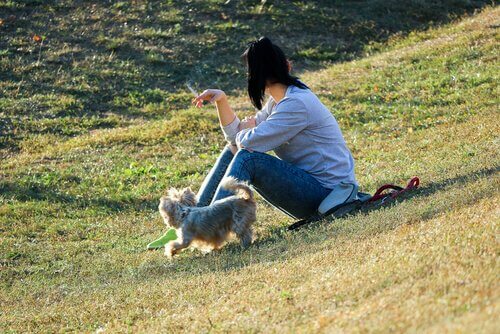 padrona fuma al parco mentre sta col suo cane