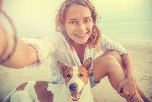 Ragazza si fa un selfie in spiaggia con il cane