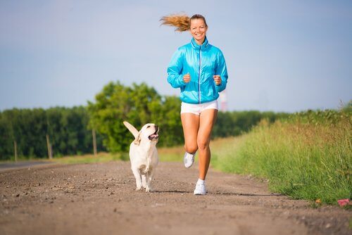 Ragazza sorridente corre con il suo cagnolino bianco
