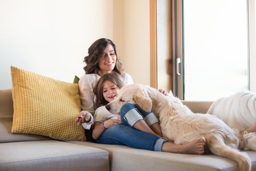 Madre e figlia sul divano col cane