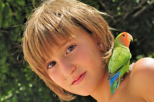 Bambina con un pappagallo sulla spalla