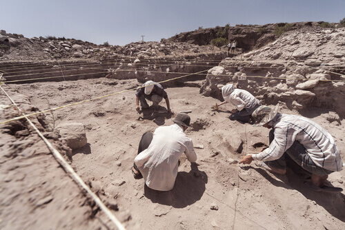 Archeologi scavano in un sito assolato.
