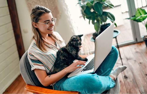 Donna al computer col suo gatto.