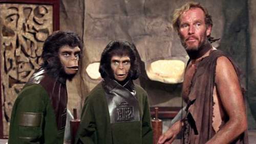 Charlton Heston e due attori che impersonano le scimmie.
