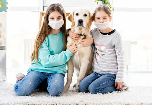 Bambine con la mascherina e il loro cane.