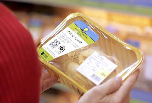Persona che compra al supermercato del pollo confezionato con il codice QR.